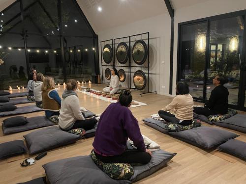 un groupe de personnes assises à même le sol dans un cours de yoga dans l'établissement Château Wellness Exclusif - Yoga et Événements Luxe, Loire Valley, à Lassay-sur-Croisne