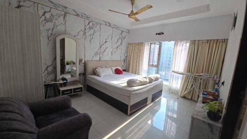 a bedroom with a bed and a couch and a mirror at Duplex Penthouse in Kolkata