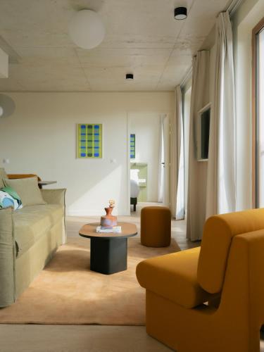 a living room with a couch and a table at Edgar Suites - Église in Paris