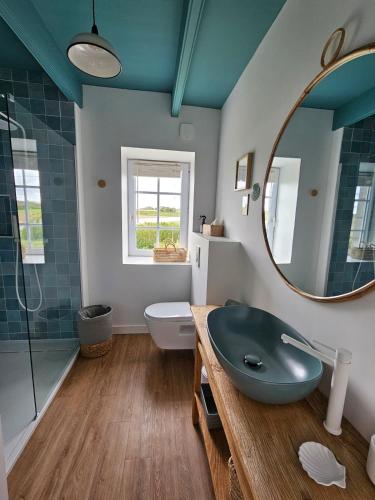 une salle de bain avec un lavabo et un miroir dans l'établissement Maison de famille Ty Pampa, à Sibiril