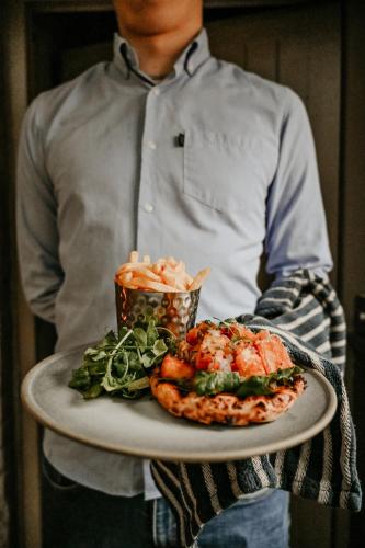 a man holding a plate of food on a table at The Boot Inn in Burton upon Trent