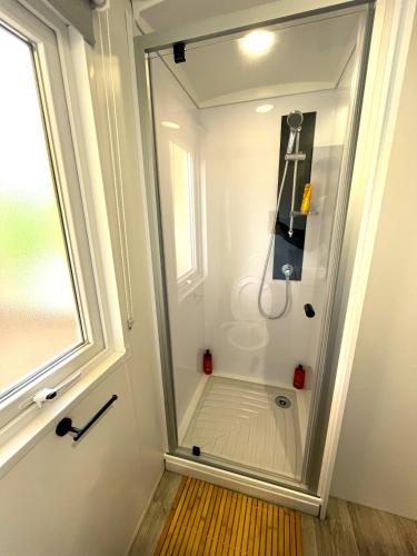 La salle de bains est pourvue d'une douche à l'italienne et d'une fenêtre. dans l'établissement Mobilhome 7 personnes climatisé - Camping 4 étoiles, à Lège-Cap-Ferret