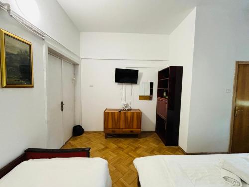 a room with two beds and a television in it at Iancu Apartments in Bucharest