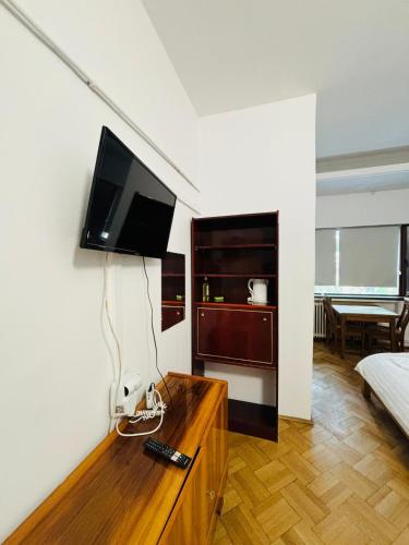 a living room with a television on a wall at Iancu Apartments in Bucharest
