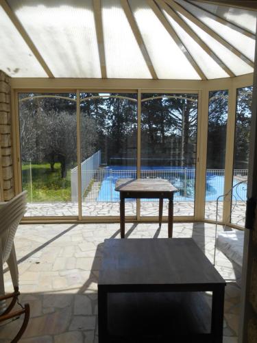 un pavillon avec une table et une piscine à l'extérieur dans l'établissement Villa Provençale avec piscine, à Pernes-les-Fontaines