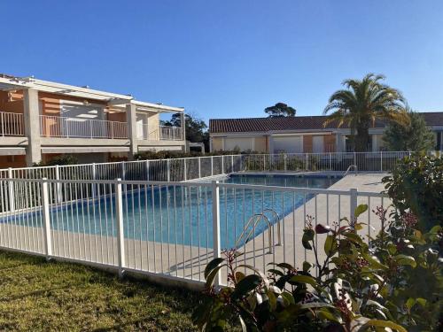 une clôture autour d'une piscine en face d'une maison dans l'établissement Appartement climatisé, parking privé, plages à proximité - FR-1-100-352, à Cavalaire-sur-Mer