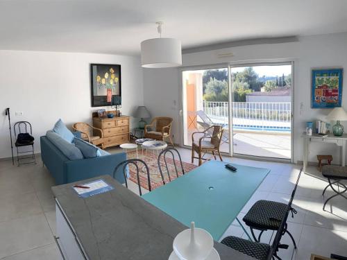 un salon avec un canapé bleu et une table dans l'établissement Appartement climatisé, parking privé, plages à proximité - FR-1-100-352, à Cavalaire-sur-Mer