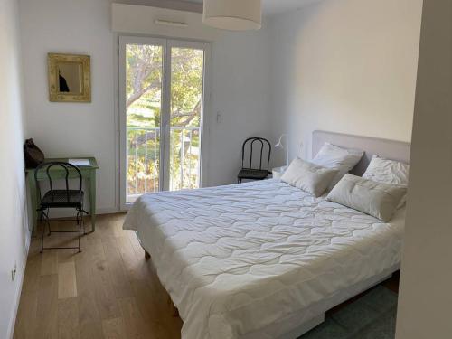 une chambre avec un grand lit et une fenêtre dans l'établissement Appartement climatisé, parking privé, plages à proximité - FR-1-100-352, à Cavalaire-sur-Mer