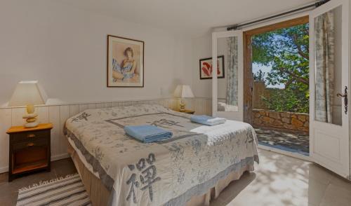 une chambre avec un lit et une fenêtre dans l'établissement Villa L'ile Bleue, à Ramatuelle