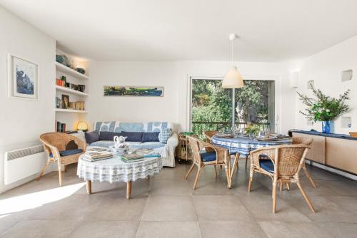 un salon avec une table, des chaises et un canapé dans l'établissement Villa L'ile Bleue, à Ramatuelle