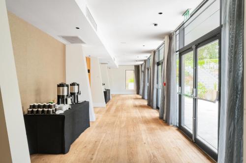 a hallway of an office with a table and windows at Crowne Plaza Gerrards Cross by IHG in Beaconsfield