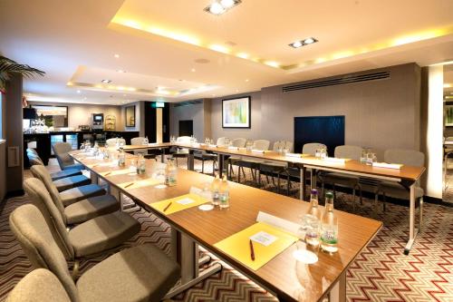 a conference room with long tables and chairs at Crowne Plaza Gerrards Cross by IHG in Beaconsfield