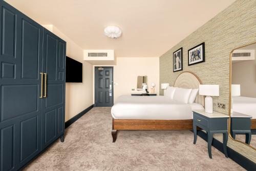 a bedroom with a large bed and a mirror at Hotel Indigo London - Kensington by IHG in London