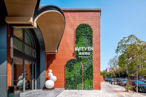a brick building with a green hedge on it at EVEN Hotel Quanzhou City Center by IHG in Quanzhou