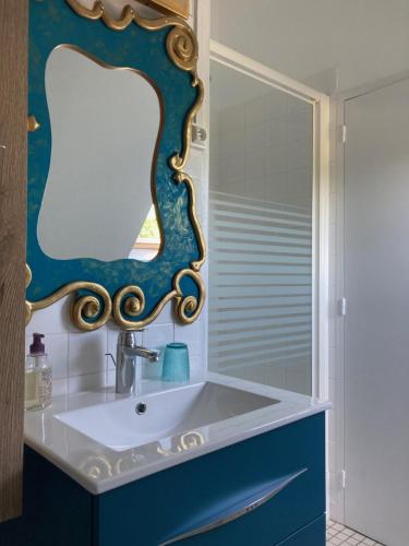 une salle de bain avec un lavabo et un miroir dans l'établissement Maison dans le Parc du Chateau Rochecave, à Larçay