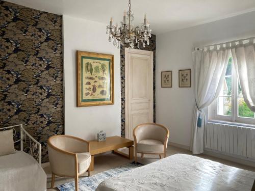 une chambre avec un lit, une table et un lustre dans l'établissement Maison dans le Parc du Chateau Rochecave, à Larçay