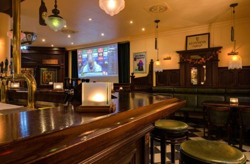 a bar with a television in a pub at Hotel Aquamarin in Kühlungsborn