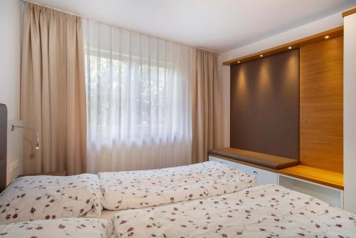 a bedroom with two beds and a window at Obst- und Ferienhof Lehle in Immenstaad am Bodensee