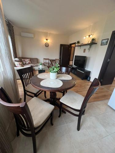 un soggiorno con tavolo e sedie in legno di Apartment Chocolate Ravda a Ravda