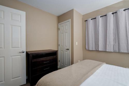 a bedroom with a bed and a dresser and a window at The Perch at Kimberling Crossing in Kimberling City