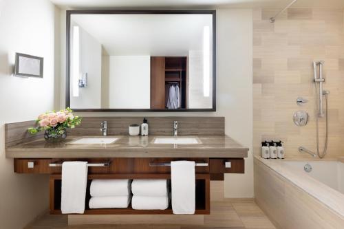 a bathroom with two sinks and a large mirror at The Langham, New York, Fifth Avenue in New York