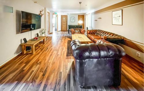 a living room with leather couches and a wooden floor at Nice Apartment In Höör in Höör
