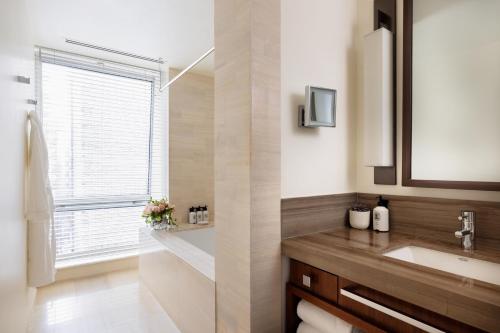 a bathroom with a sink and a mirror and a window at The Langham, New York, Fifth Avenue in New York