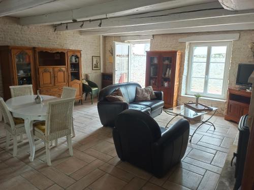 a living room with a couch and a table at Belle maison familiale près de La Rochelle in Ferrières