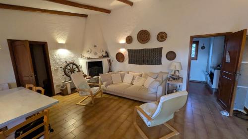un soggiorno con un divano bianco e sedie di Villetta La Casa Vecchia Baja Sardinia a Cala Bitta