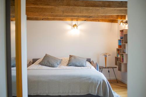 a bedroom with a white bed with blue pillows at Le petit paddock in Villeneuve-lès-Cerfs