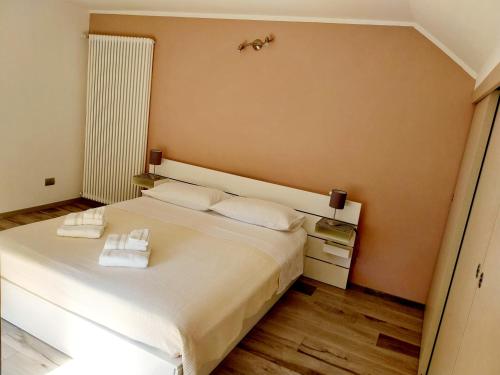 a bedroom with a bed with two towels on it at Casa Palmy in Verbania