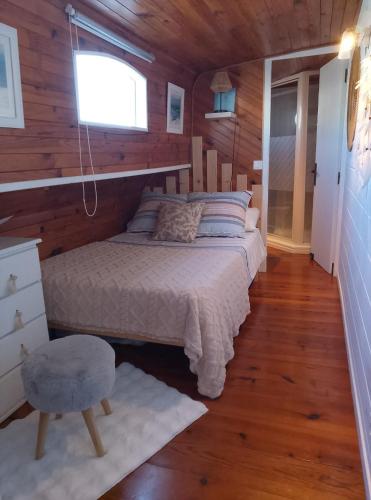 a bedroom with a bed in a room with wooden walls at PENICHE FARNIENTE CLIMATISEE - Aux Portes de la Camargue in Bellegarde