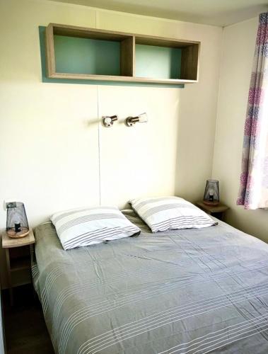 une chambre avec un lit avec deux oreillers dessus dans l'établissement Mobil Home à 100m de la mer sur terrain privé, à Plouescat