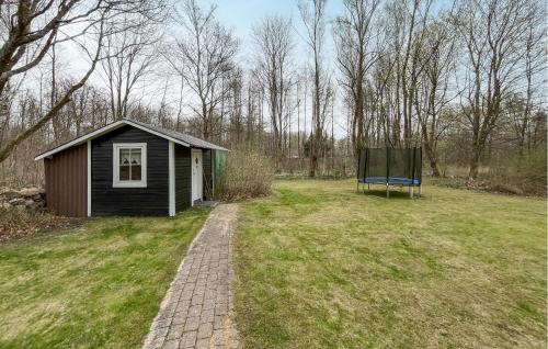 a small shed in a field with a bench at 3 Bedroom Beautiful Home In Hörby in Hörby