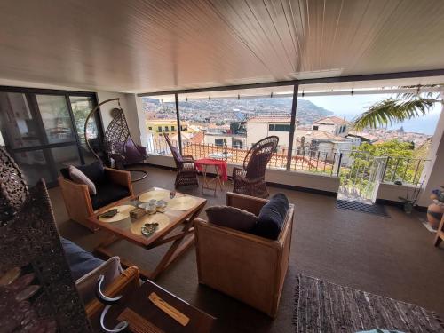 a living room with chairs and a table and a balcony at Casa Pico Musica in Funchal