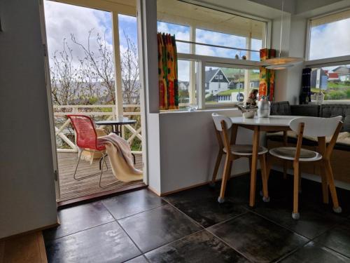 a kitchen with a table and chairs and a balcony at City center, Tórshavn in Tórshavn