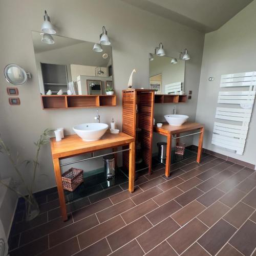une salle de bain avec deux lavabos et deux miroirs dans l'établissement Grande maison à louer Normandie, à Tamerville