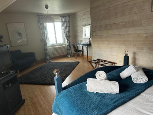 une chambre avec un lit bleu avec des serviettes dessus dans l'établissement Grande maison à louer Normandie, à Tamerville