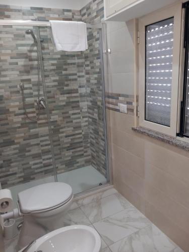 a bathroom with a toilet and a glass shower at B&b PAESTUM ROOM in Paestum