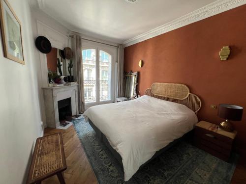 une chambre avec un lit et une cheminée dans l'établissement Bel appartement Paris Montmartre, à Paris