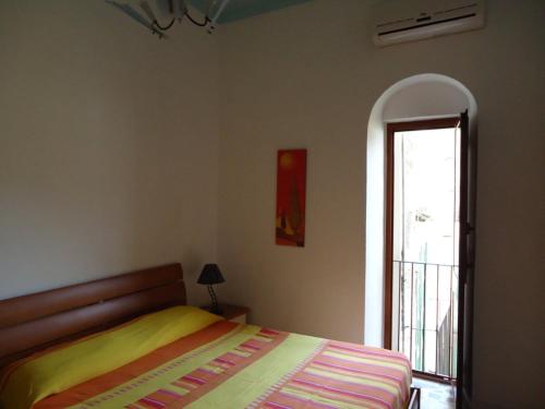 a bedroom with a bed and a large window at Appartamento Margot in Lipari