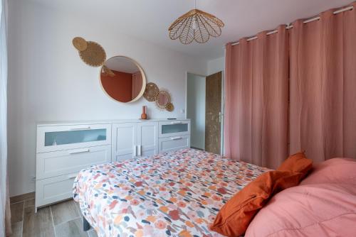 une chambre avec un lit, une commode et un miroir dans l'établissement Appartement T2 - Proche de la mer, à Fréjus
