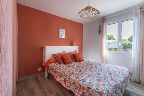 - une chambre avec un lit aux murs orange et une fenêtre dans l'établissement Appartement T2 - Proche de la mer, à Fréjus
