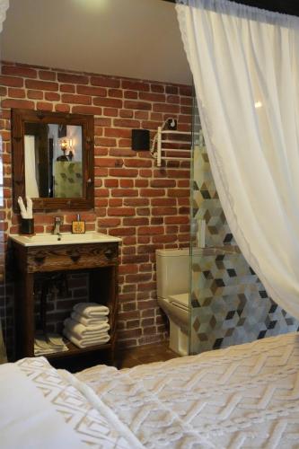 a bedroom with a bathroom with a brick wall at Curtea Domneasca in Cricova