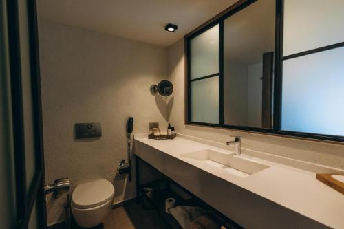 a bathroom with a sink and a mirror and a toilet at Club Marvy in Ozdere