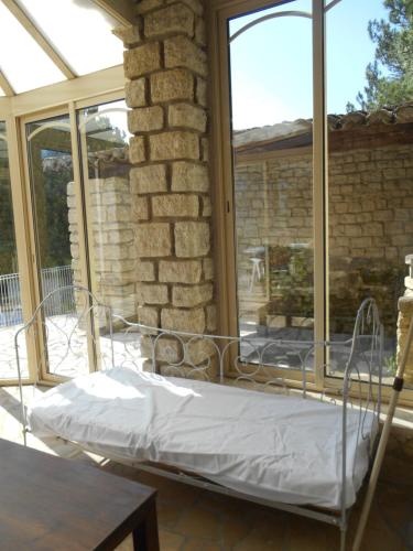 un lit dans une chambre avec une fenêtre dans l'établissement Villa Provençale avec piscine, à Pernes-les-Fontaines