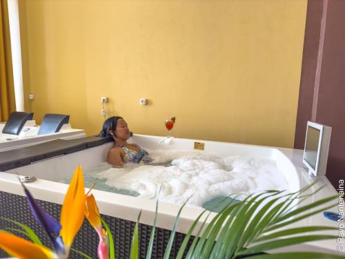 a girl in a bathtub in a hotel at Hôtel MENABE'L in Antsirabe