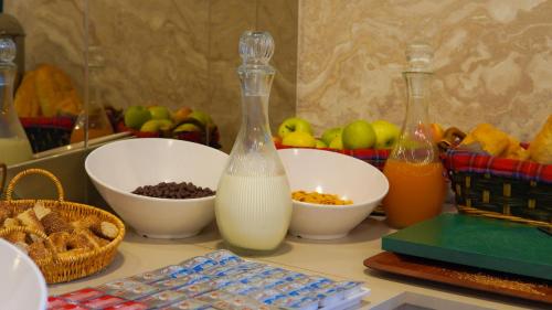 a counter with two bottles of milk and bowls of food at SİLVA DELUXE Hotel in Mezitli