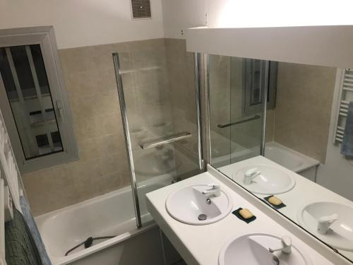 une salle de bain avec deux lavabos et une douche dans l'établissement La Dunette, à La Grande Motte