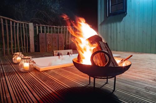 a fire pit on a deck with a hot tub at Lapin Cottage in Long Bredy